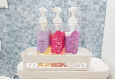 a shelf with four bottles of hair products on a toilet at Lodging Tokyo Shibamata in Tokyo