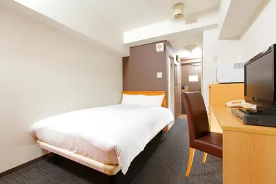 a bedroom with a bed and a desk with a television at FLEXSTAY INN Shirogane in Tokyo