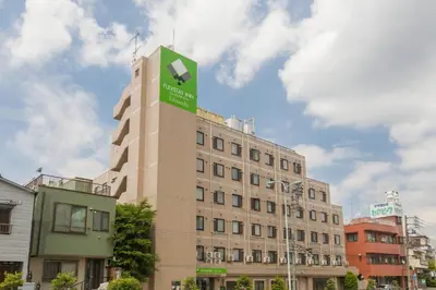a building with a green sign on top of it at FLEXSTAY INN Tokiwadai in Tokyo