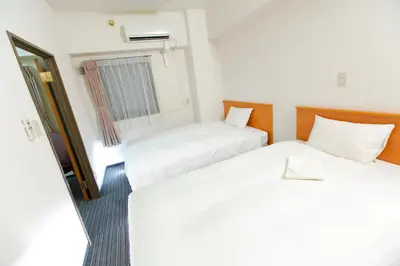 a hotel room with two beds and a window at FLEXSTAY INN Tokiwadai in Tokyo
