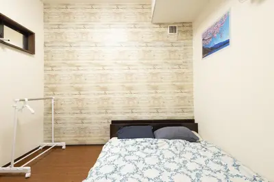 a bedroom with a bed and a wooden wall at Comptoir Shinjuku - Vacation STAY 15325 in Tokyo