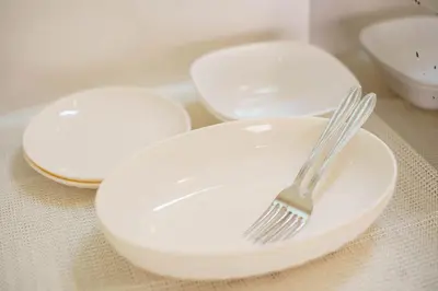 three white plates and a fork on a table at BURan House in Tokyo