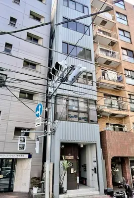 a traffic light in front of a tall building at \u30b5\u30af\u30e9\u30b7\u30e3\u30c9\u30a6\u5fa1\u5f92\u753a in Tokyo