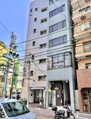 a motorcycle parked in front of a tall building at \u30b5\u30af\u30e9\u30b7\u30e3\u30c9\u30a6\u5fa1\u5f92\u753a in Tokyo