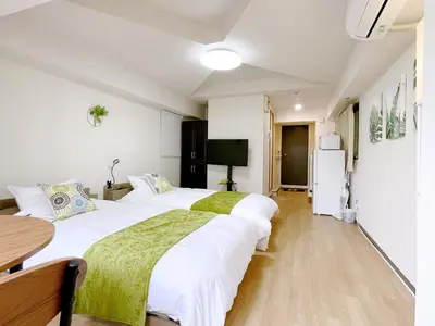 two beds in a room with a table and a refrigerator at \u30b5\u30af\u30e9\u30b7\u30e3\u30c9\u30a6\u5fa1\u5f92\u753a in Tokyo