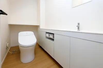 a white bathroom with a toilet and a sink at Kiyosumi SOHO by Tranova in Tokyo