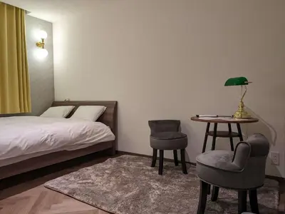 a bedroom with a bed and a table and chairs at MARUKOU HOTEL in Tokyo