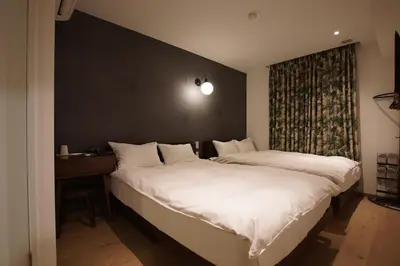 a bedroom with two beds and a large window at MARUKOU HOTEL in Tokyo