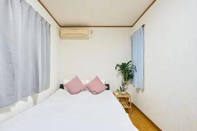 a bedroom with a white bed with pink pillows at 9min to kitasenju sation 6min to shopping street quiet area in Tokyo