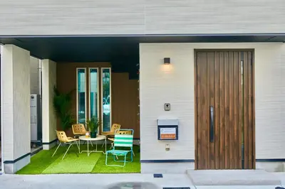 a house with a patio with a table and chairs at Shinjuku 'Orange County' Villa in Tokyo