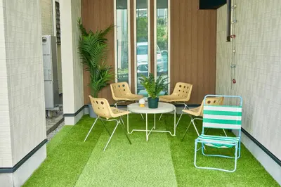 a balcony with a table and chairs on the grass at Shinjuku 'Orange County' Villa in Tokyo