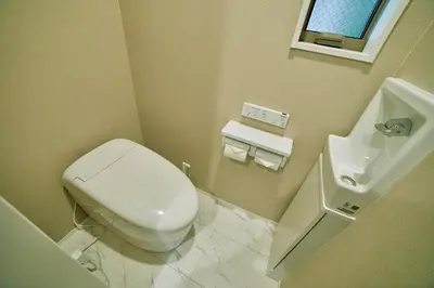 a bathroom with a white toilet and a sink at Shinjuku 'Orange County' Villa in Tokyo