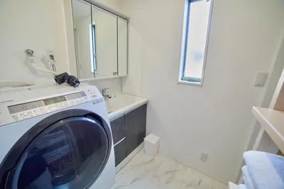 a washing machine in a bathroom with a sink at Shinjuku 'Orange County' Villa in Tokyo