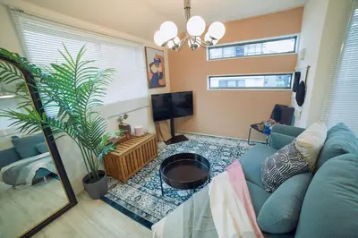 a living room with a blue couch and a tv at Shinjuku 'Orange County' Villa in Tokyo