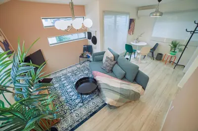 a living room with a blue couch and a table at Shinjuku 'Orange County' Villa in Tokyo