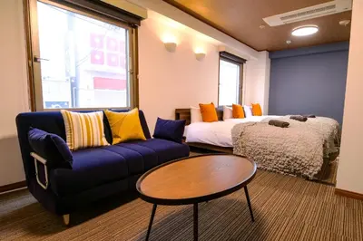 a room with a couch and a bed and a table at J-Court Oshiage in Tokyo