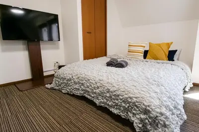 a bedroom with a bed and a flat screen tv at J-Court Oshiage in Tokyo