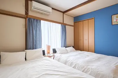 two beds in a room with a blue wall at Total 107square meter 4min to nearest staion Max16pp in Tokyo