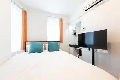 a bedroom with a bed and a flat screen tv at Verde\u6c60\u888b in Tokyo