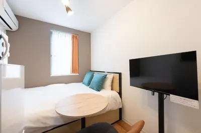 a small bedroom with a bed and a table at Verde\u6c60\u888b in Tokyo
