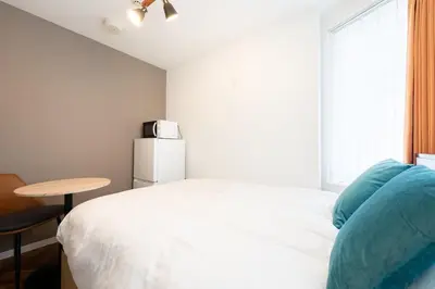 a bedroom with a bed and a table and a window at Verde\u6c60\u888b in Tokyo