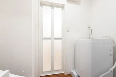 a white bathroom with a toilet and a window at Verde\u6c60\u888b in Tokyo