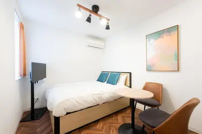 a bedroom with a bed and a table and chairs at Verde\u6c60\u888b in Tokyo