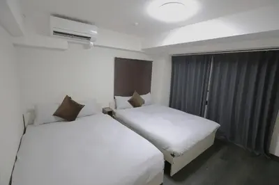 two beds in a hotel room with white sheets at NEW OPEN 4BR, 110\u33a1 Walk to Asakusa in Tokyo