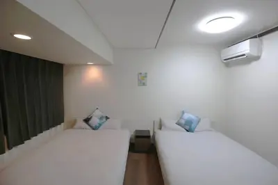 a room with two white beds and a tv at NEW OPEN 4BR, 110\u33a1 Walk to Asakusa in Tokyo