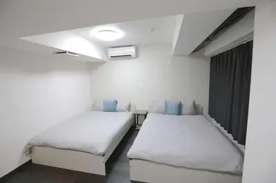 two beds in a room with white walls at NEW OPEN 4BR, 110\u33a1 Walk to Asakusa in Tokyo