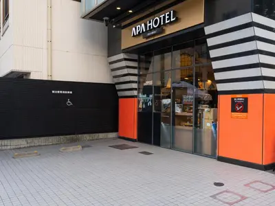 a store front of a building with orange doors at APA Hotel Higashi Nihombashi Ekimae in Tokyo