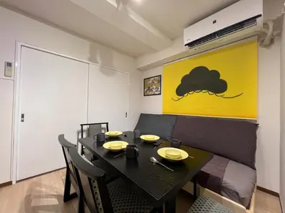 a dining room with a black table and chairs at 山手線池袋駅 徒歩6分 東池袋駅徒歩3分 2~5人 エレベーター WIFI 新宿/渋谷/銀座/築地/浅草/原宿近い！ in Tokyo