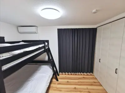 a bedroom with a bunk bed and a closet at Private Hotel Season Spring in Tokyo