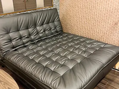 a black leather couch in a room at 1st STEP HOTEL \u30d5\u30a1\u30fc\u30b9\u30c8\u30b9\u30c6\u30c3\u30d5\u309a\u30db\u30c6\u30eb in Tokyo
