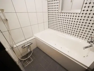 a bathroom with a white tub and a sink at 1st STEP HOTEL \u30d5\u30a1\u30fc\u30b9\u30c8\u30b9\u30c6\u30c3\u30d5\u309a\u30db\u30c6\u30eb in Tokyo
