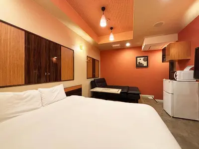 a hotel room with a white bed and a desk at 1st STEP HOTEL \u30d5\u30a1\u30fc\u30b9\u30c8\u30b9\u30c6\u30c3\u30d5\u309a\u30db\u30c6\u30eb in Tokyo