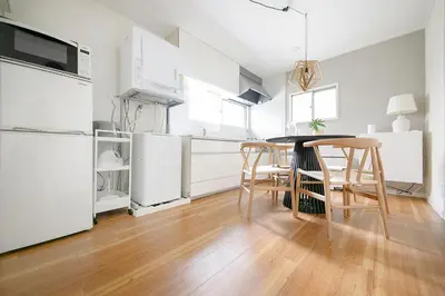 a kitchen with white appliances and a table and chairs at Pufuka Kanegafuchi \u3077\u3075\u304b\u9418\u30f6\u6df5 in Tokyo
