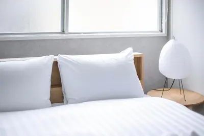 a bed with white sheets and pillows and a window at Pufuka Kanegafuchi \u3077\u3075\u304b\u9418\u30f6\u6df5 in Tokyo
