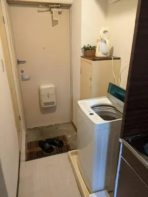 a small bathroom with a washing machine in the floor at Wise Park Mukojima in Tokyo