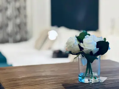 a glass vase with white flowers in it on a table at Hotel COMACHI in Tokyo
