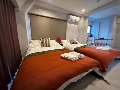 two beds sitting next to each other in a room at Hotel COMACHI in Tokyo