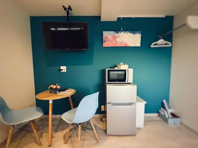 a small room with a table and a microwave at Hotel COMACHI in Tokyo