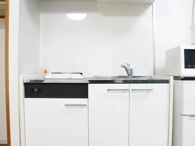 a kitchen with white cabinets and a sink at Duo Scala Shinjuku \u6771\u65b0\u5bbf in Tokyo