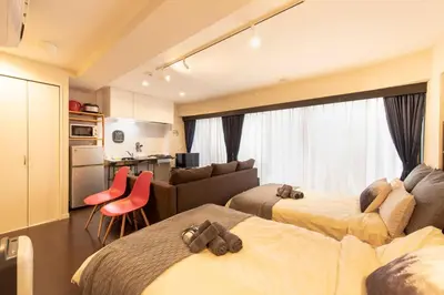a hotel room with two beds and a couch at \u30ea\u30ce\u30b9\u30bf\u30a4\u30eb\u62bc\u4e0a in Tokyo