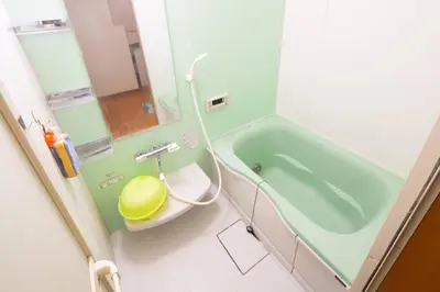 a bathroom with a green tub and a toilet at \u8981\u753a \u4e00\u6238\u5efa\u8cb8\u5bb6 in Tokyo