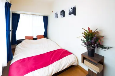 a bedroom with a red and white bed and a window at \u8981\u753a \u4e00\u6238\u5efa\u8cb8\u5bb6 in Tokyo