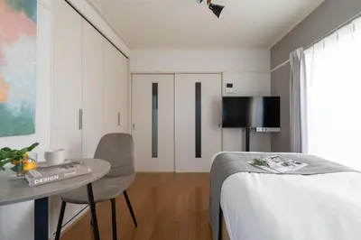 a bedroom with a bed and a table and a television at \u30d1\u30eb\u30b3\u30fc\u30c8\u6c60\u888b in Tokyo
