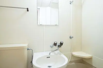 a white bathroom with a sink and a shower at \u30d1\u30f3\u30b7\u30aa\u30f3\u62bc\u4e0a in Tokyo