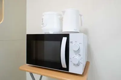 a microwave sitting on top of a wooden table at \u30d1\u30f3\u30b7\u30aa\u30f3\u62bc\u4e0a in Tokyo