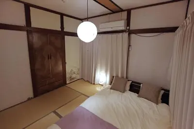 a bedroom with a large bed and a chandelier at \u6e0b\u8c37\u672c\u753a4\u4e01\u76ee\u6238\u5efa in Tokyo